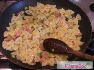 Amalgamate la pasta con le fave, la pancetta e la cipolla in padella